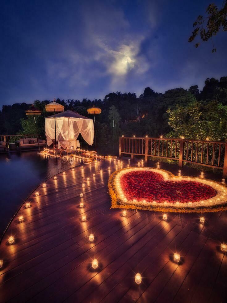 Candlelit heart-shaped rose petal setup for a romantic evening